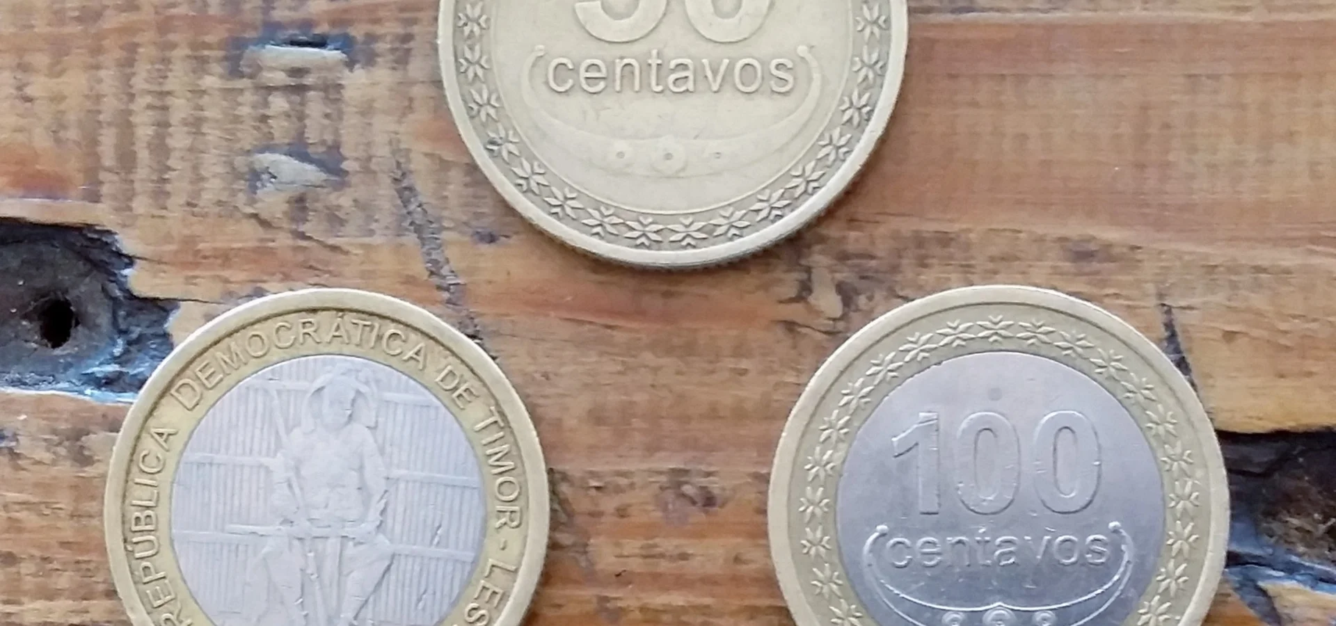 US dollar notes and Timor-Leste centavos coins side by side
